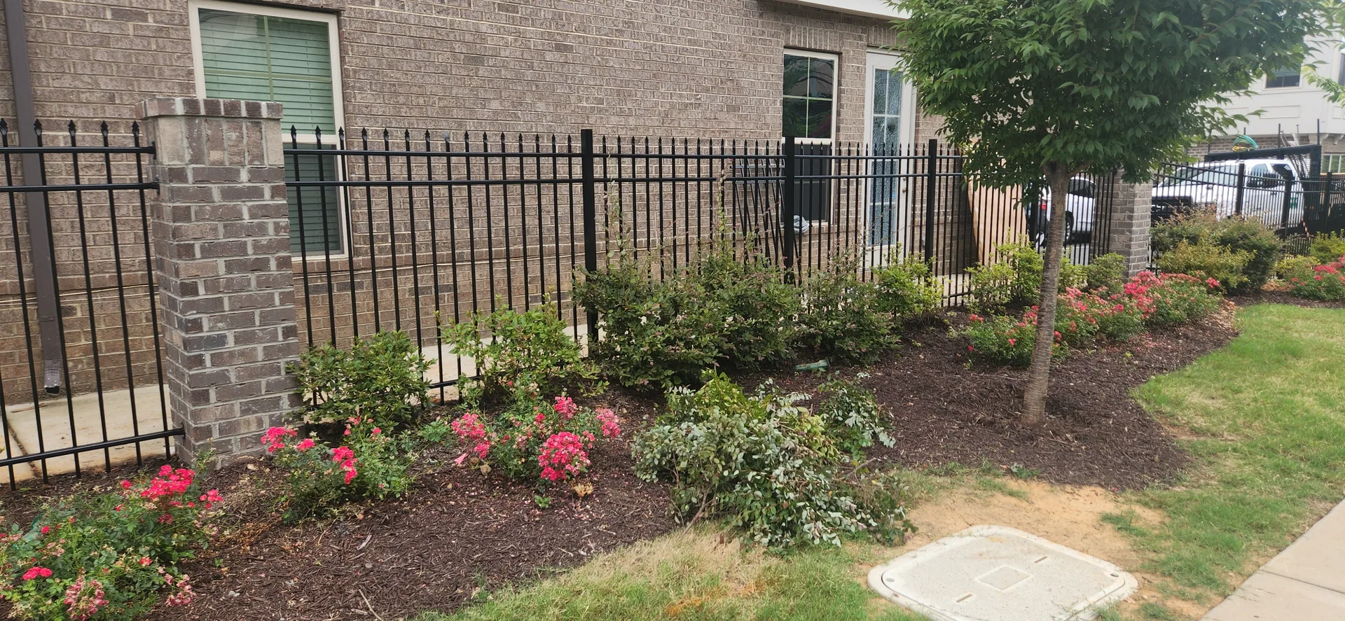 Black aluminum picket fence brick column mulch flower bed gaston county