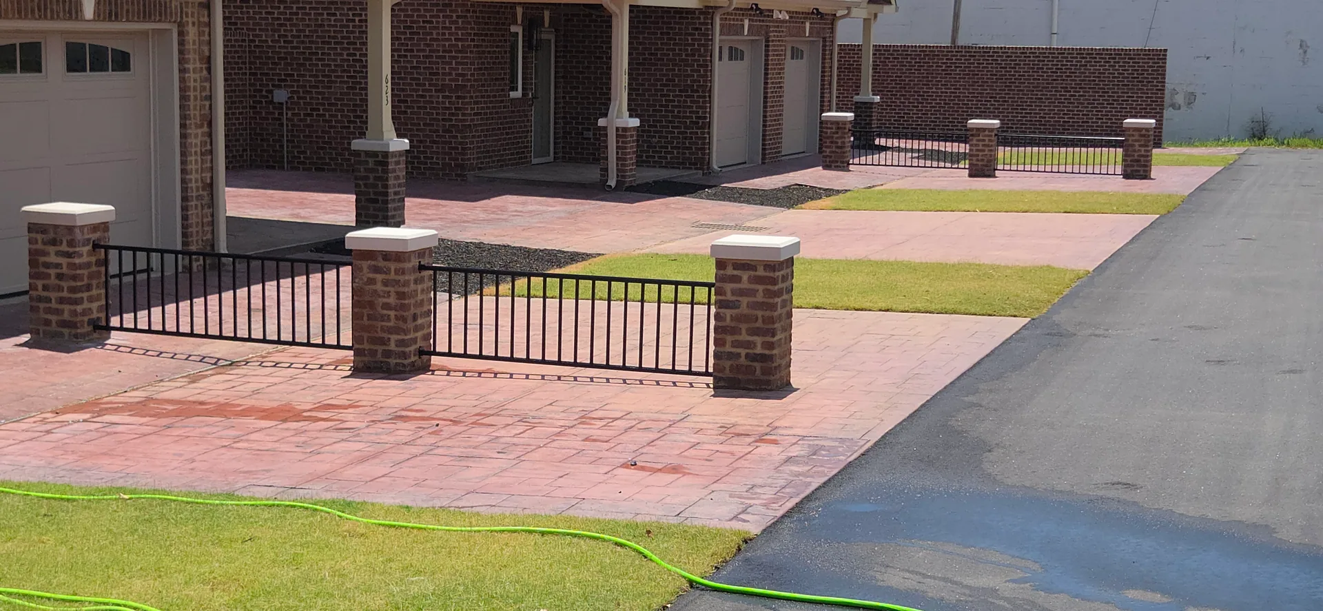 Black aluminum rail fence brick columns stamped concrete townhomes gastonia nc