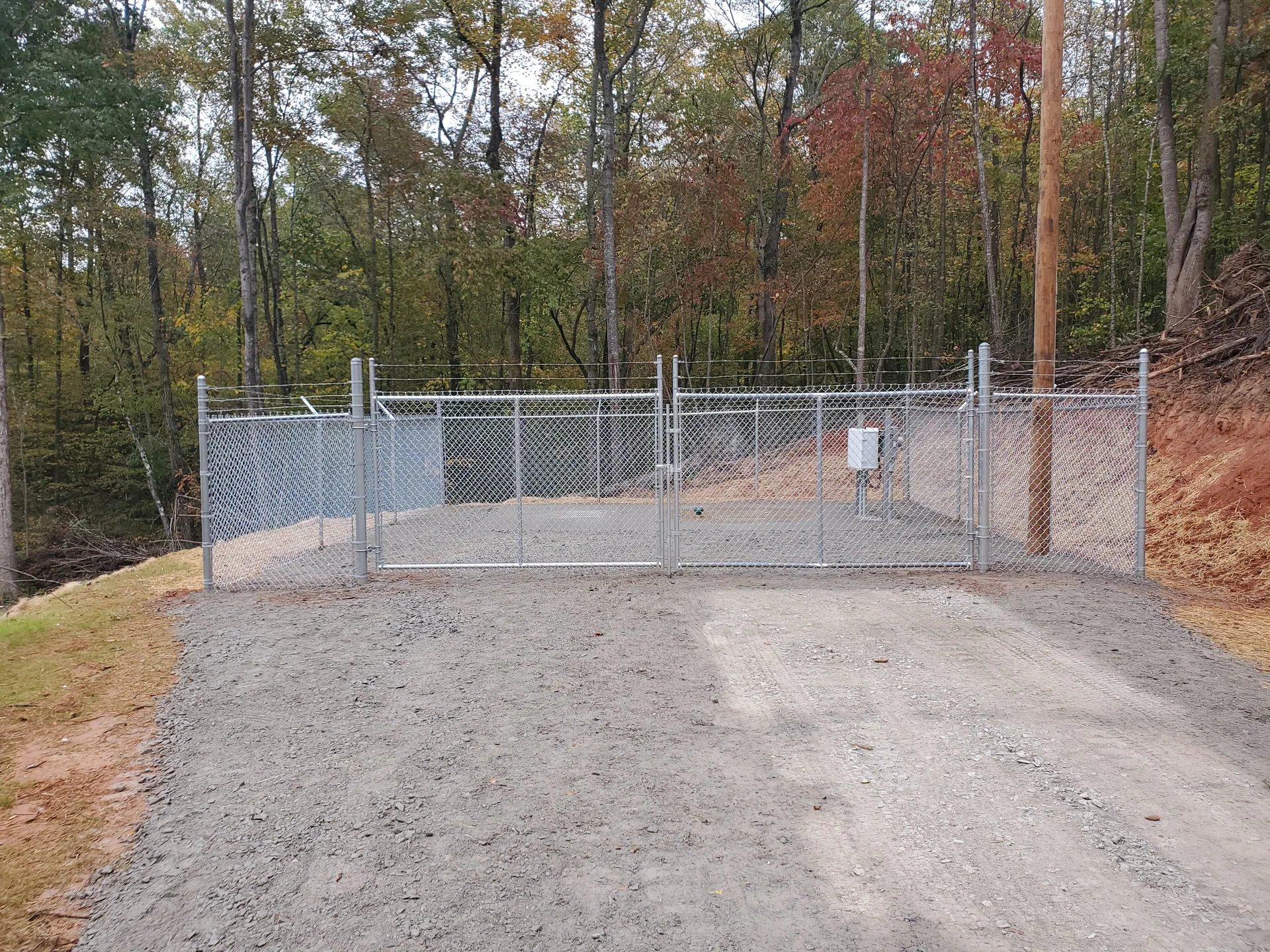 Galvanized chain link double gate gravel drive wooded site gastonia