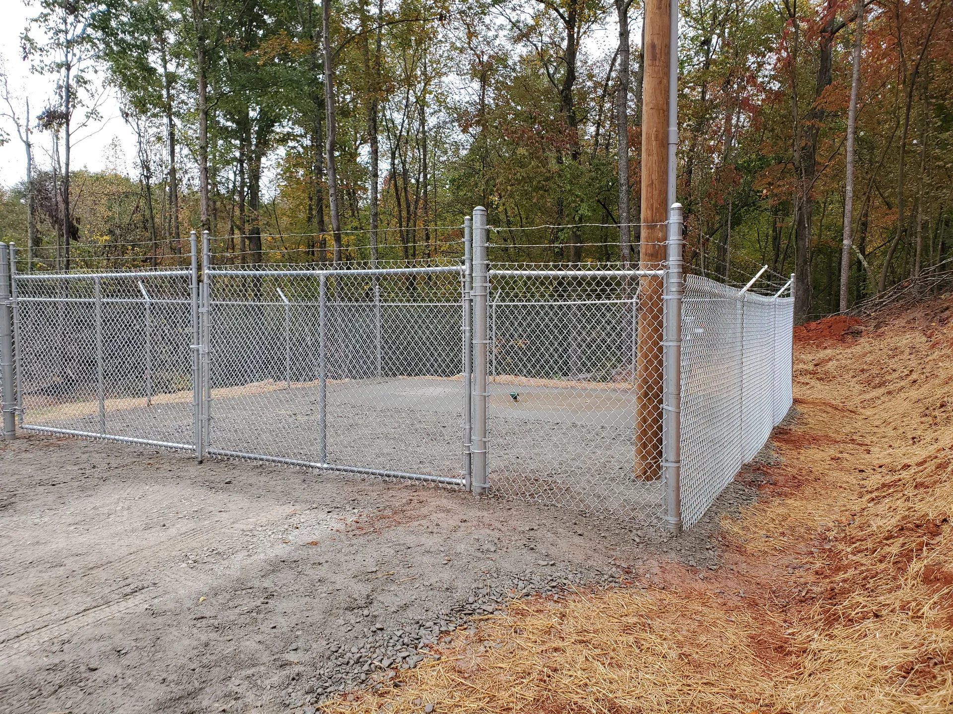Galvanized chain link utility site enclosure double gate wooded hillside gaston