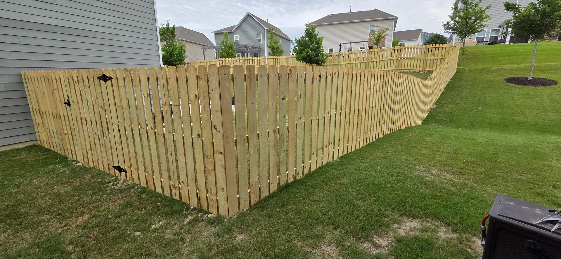 Spaced picket wood fence corner gate sloped lawn neighborhood belmont nc