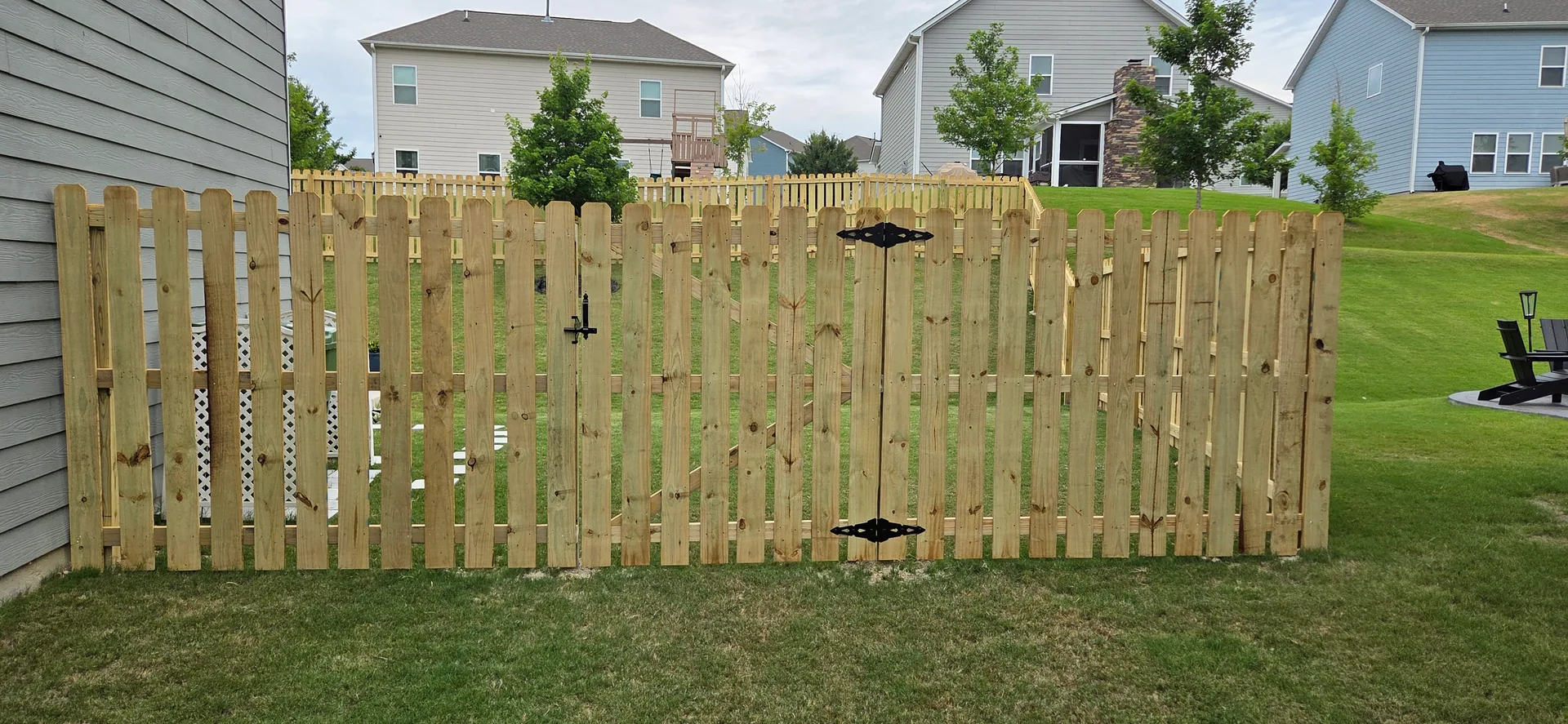 Spaced picket wood fence gate black hinges gray siding subdivision gastonia