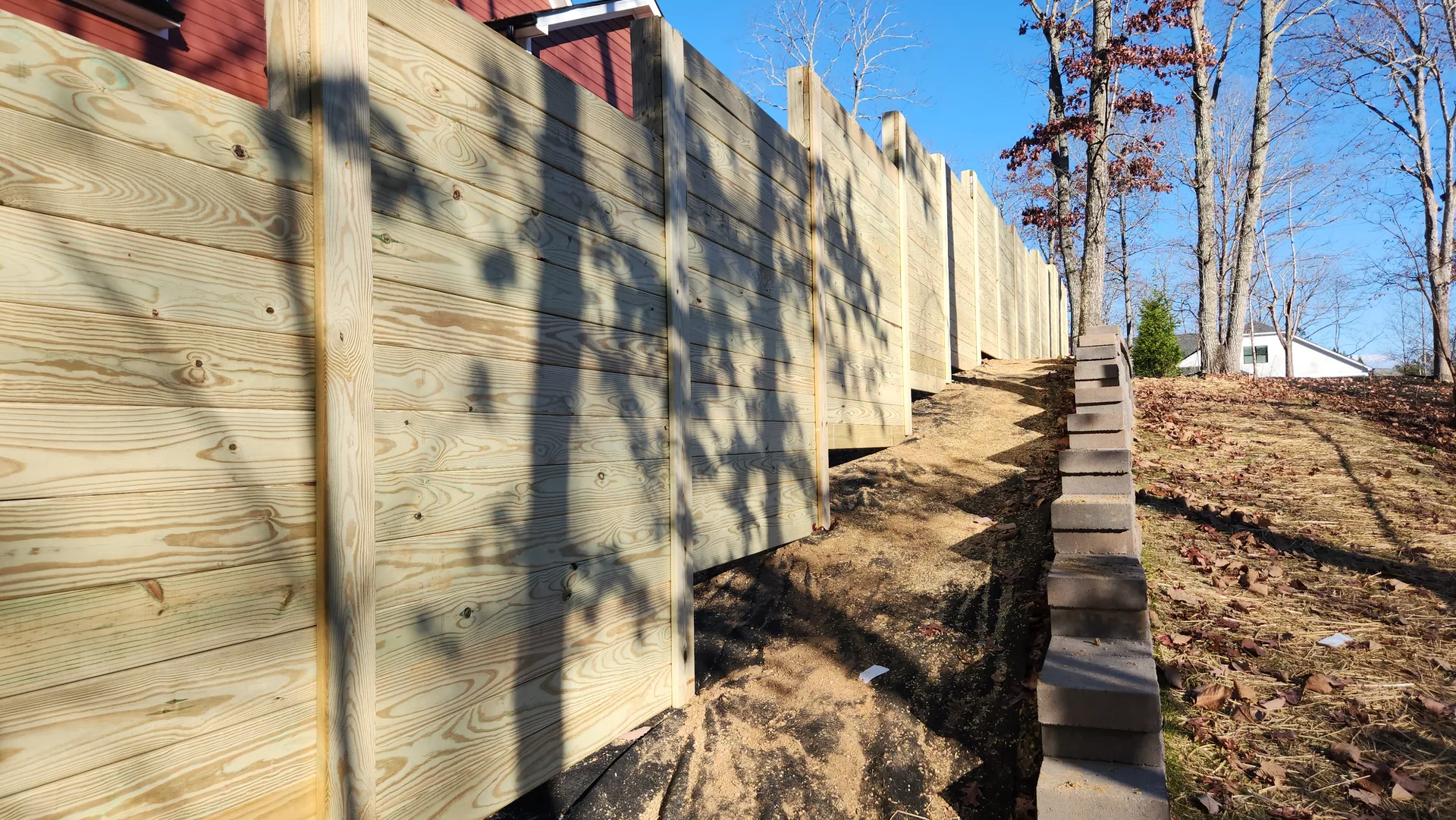 Stepped horizontal board wood fence sloped yard retaining block dallas nc