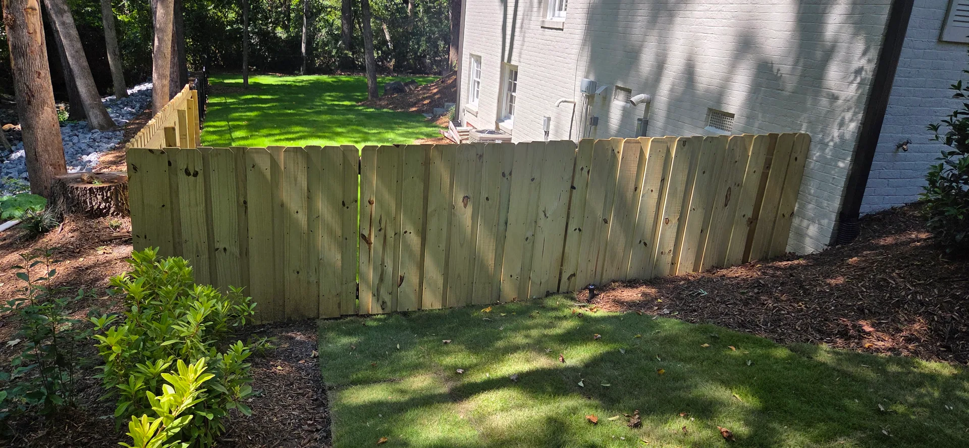 Stepped wood picket fence painted brick house sod lawn mount holly nc