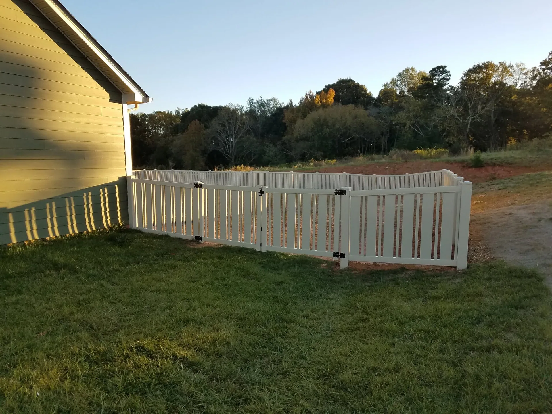Tan vinyl semi private picket fence gate attached to house yard gastonia