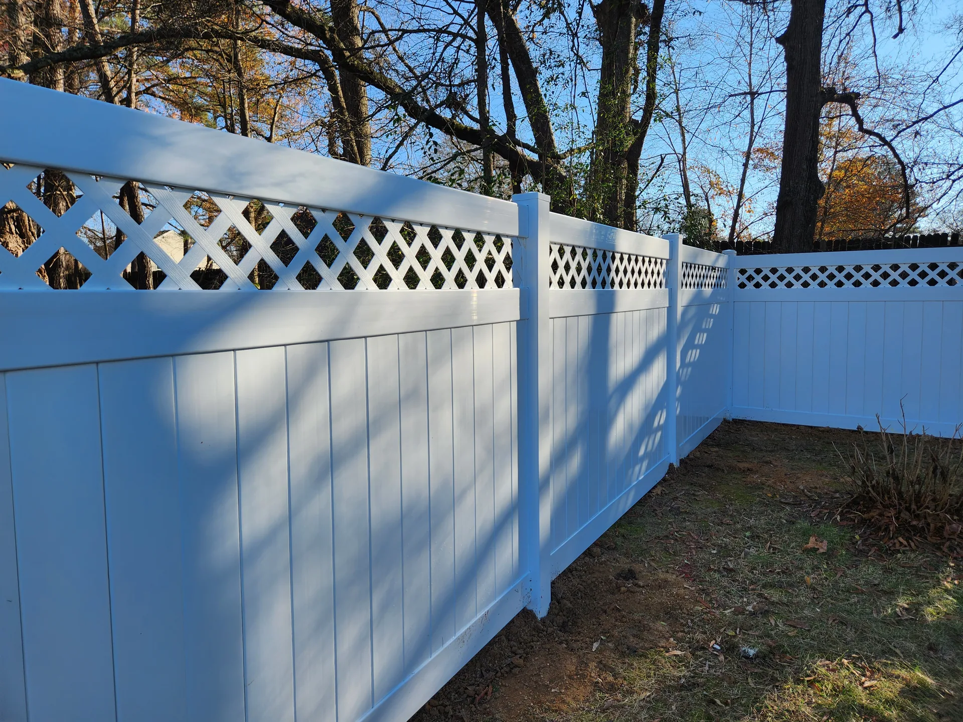White pvc lattice top fence corner bare trees dallas nc
