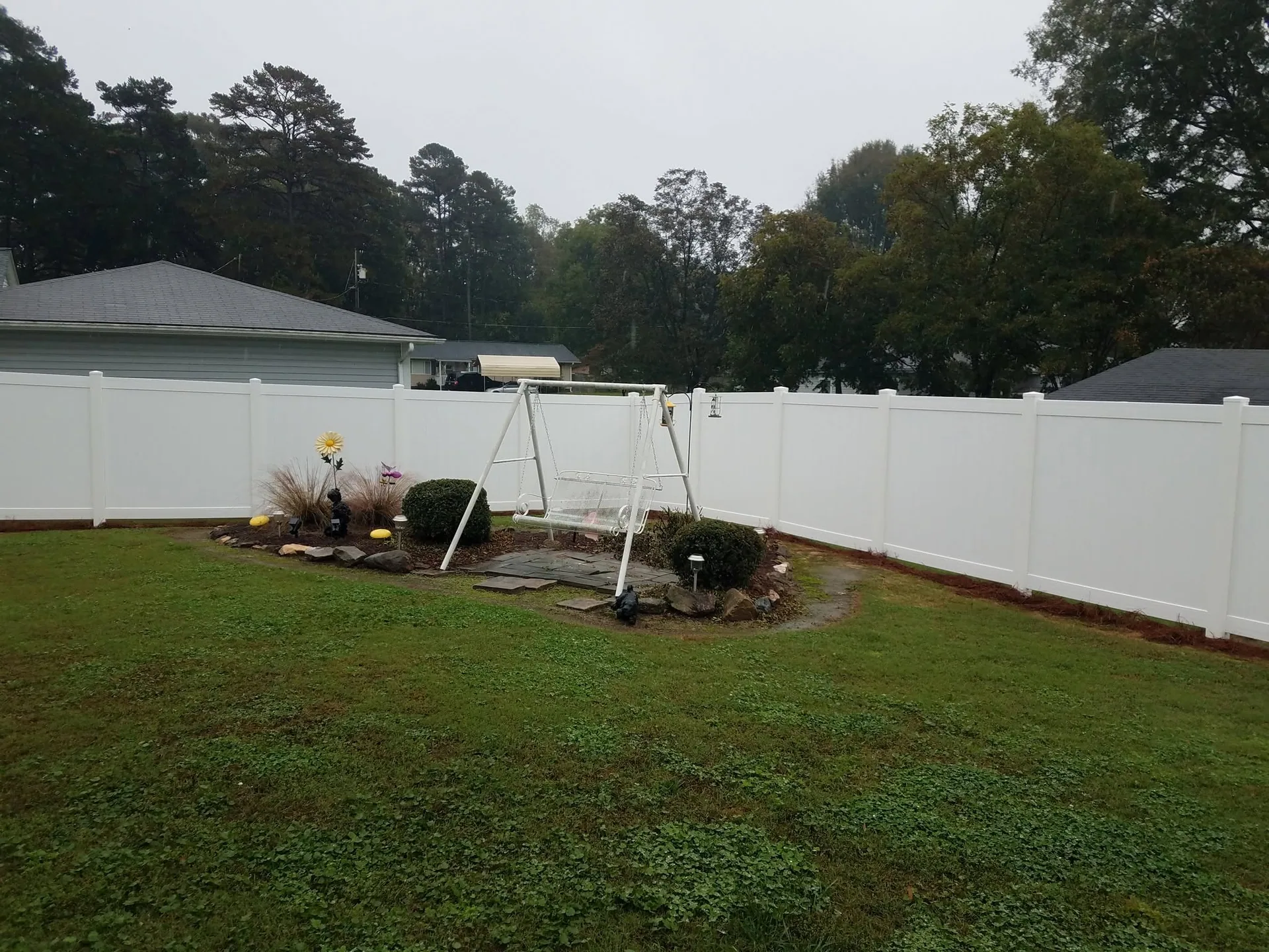 White vinyl privacy fence backyard swing set garden bed gastonia nc