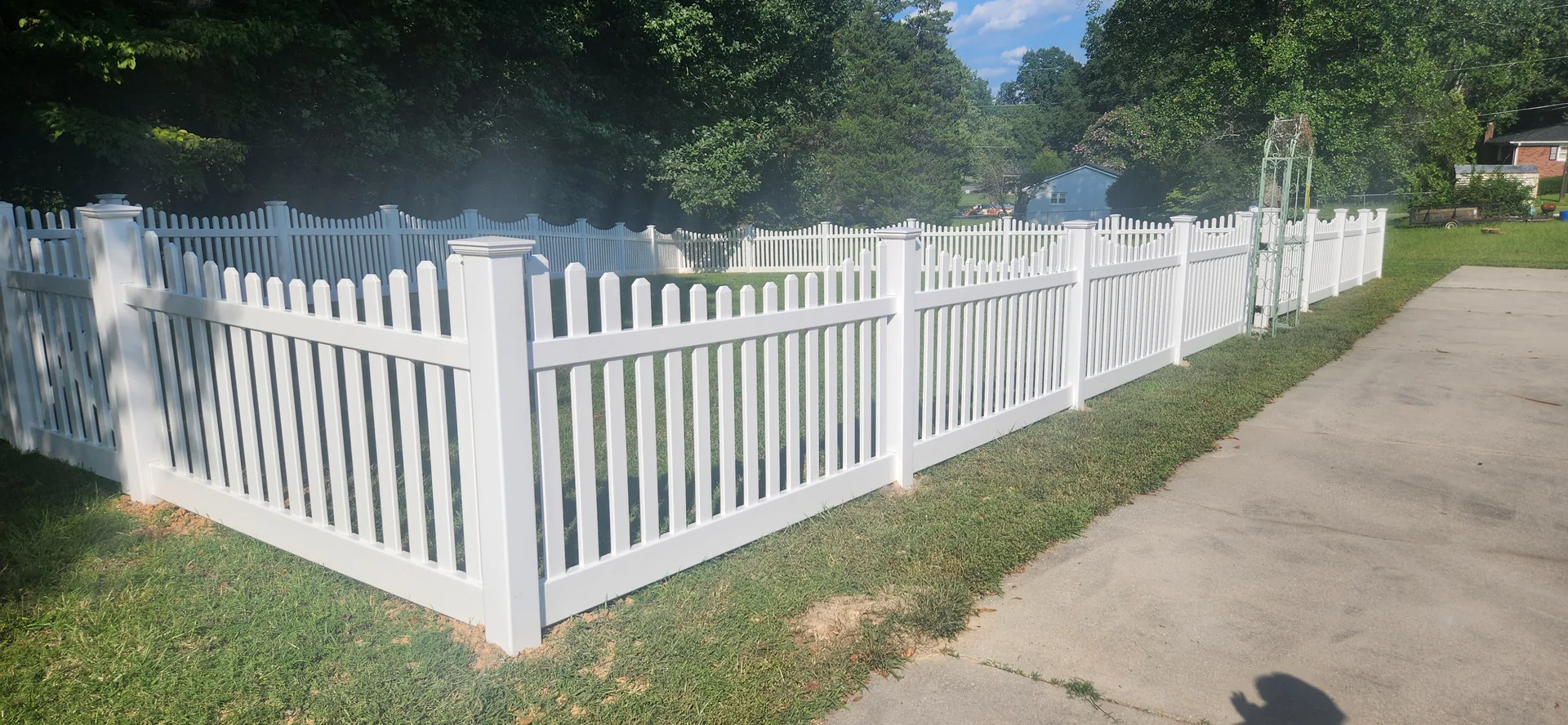 White vinyl scalloped picket fence corner yard garden arbor concrete driveway ga