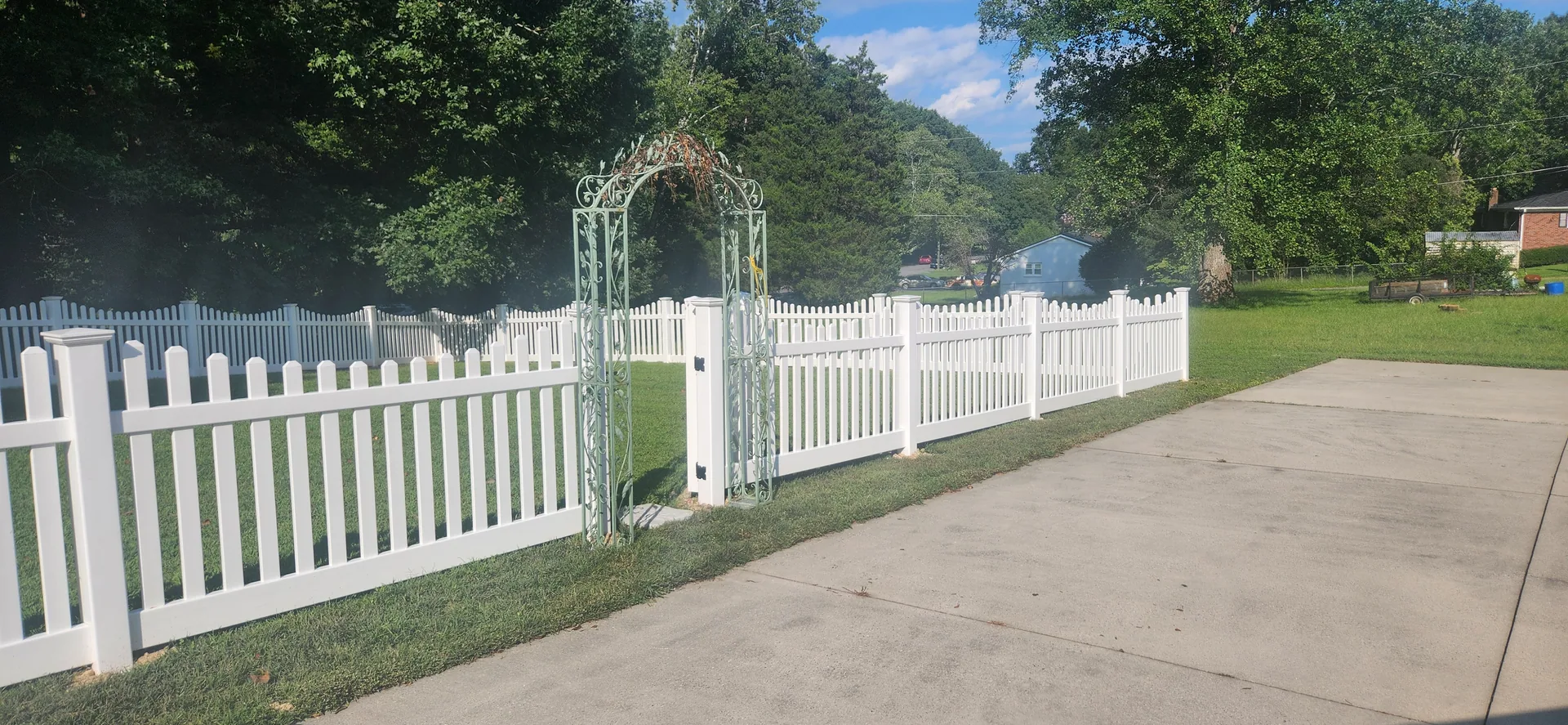 White vinyl scalloped picket fence garden arbor opening concrete drive mount hol