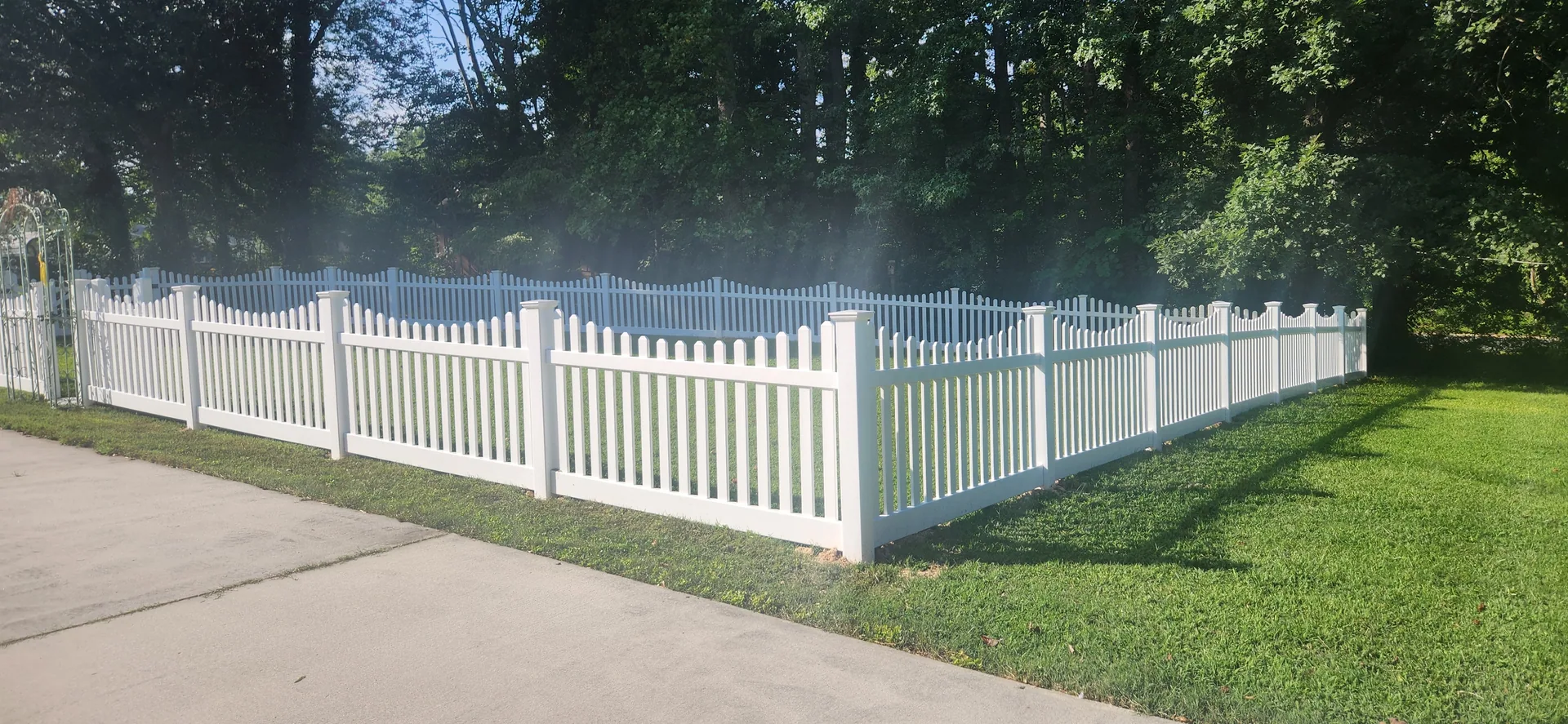 White vinyl scalloped picket fence lawn wooded backdrop mount holly nc