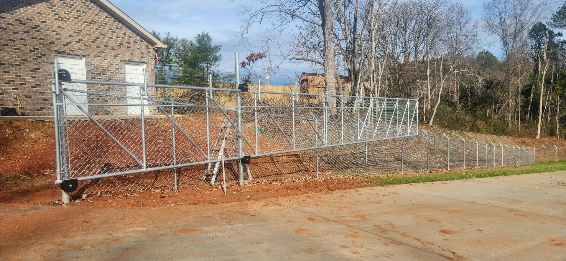 Wide galvanized chain link cantilever gate red clay brick outbuilding dallas nc