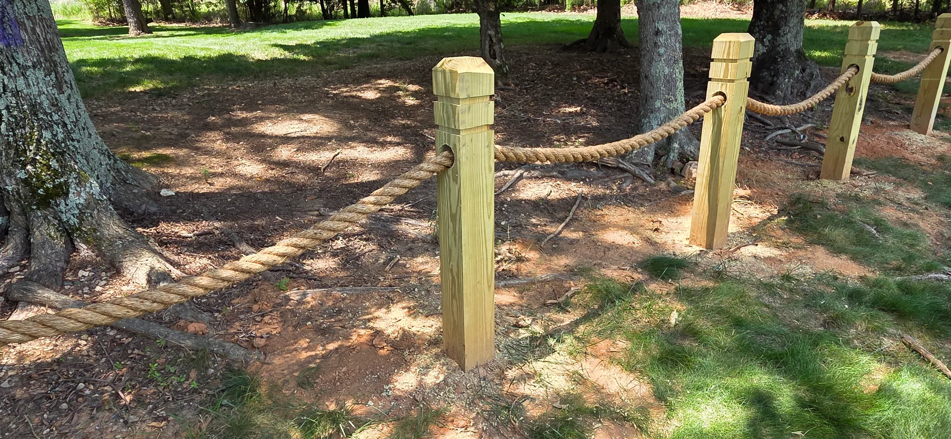 Wood post and rope barrier mature trees red clay belmont nc